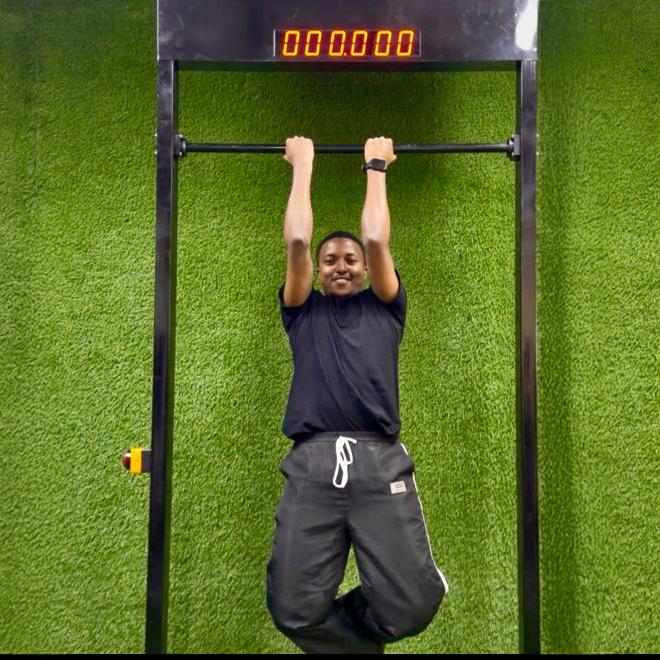 Viral 100-Second Hanging Challenge arcade machine rental for corporate events in Dubai, featuring a digital timer and participants testing their grip strength.